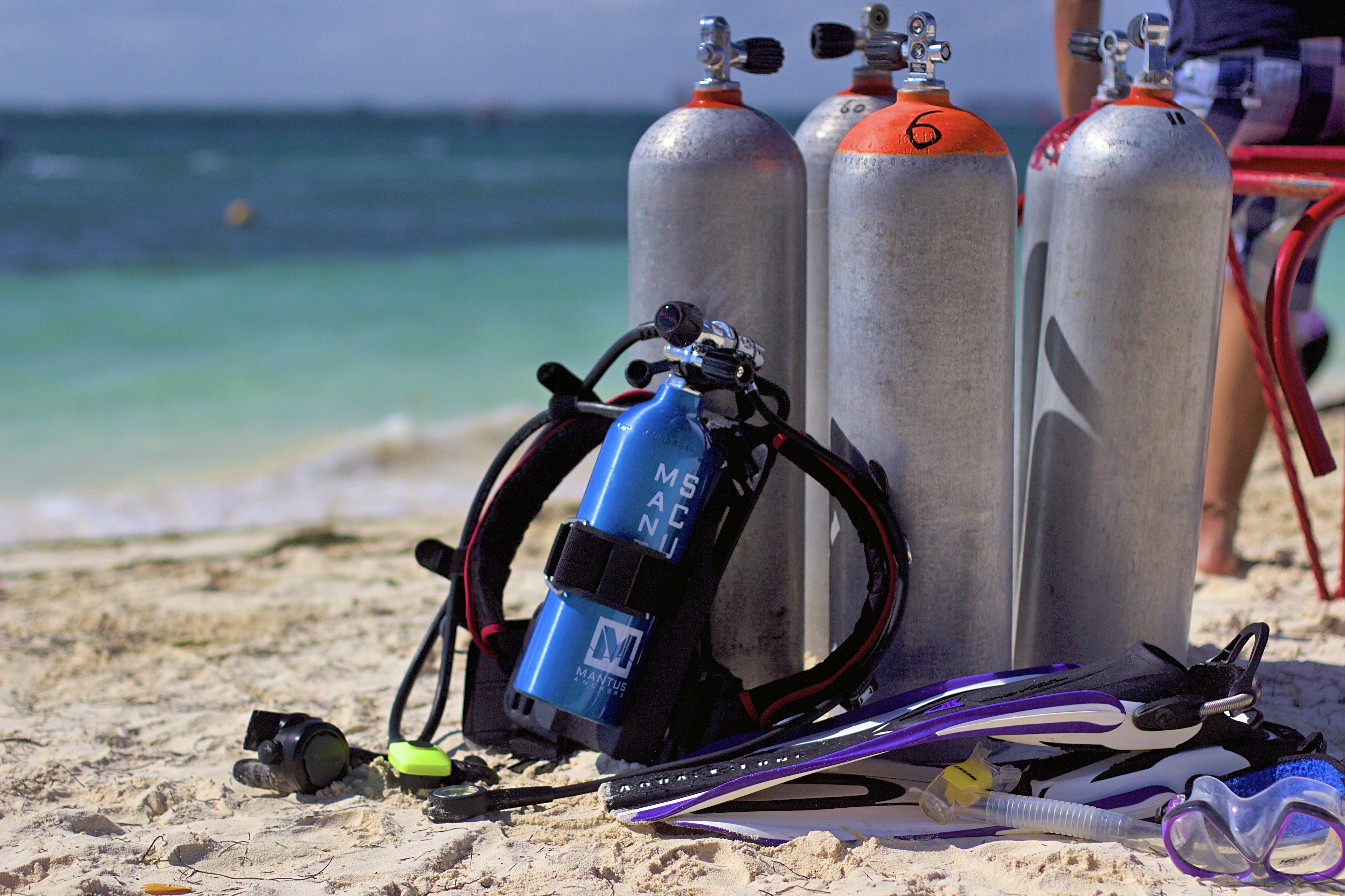 Diving gear with oxygen tanks on the sand by the ocean